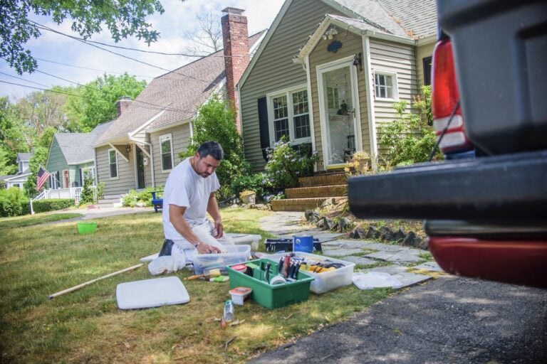 Decorator on grass sorting through decorating equipment