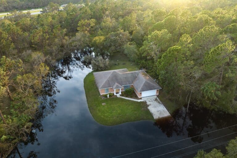 Heavy flood with high water surrounding residential houses after hurricane rainfall in Florida residential area. Consequences of natural disaster.