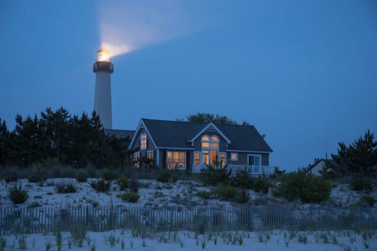 Lighthouse beaming near beach house