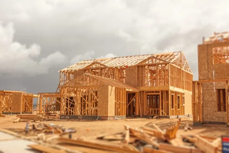 Wood Home Framing Abstract At Construction Site with Stormy Clouds Behind.