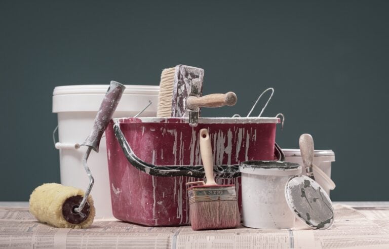 Professional painter tools on protective paper: home renovation and painting concept