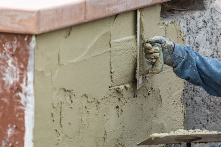 Tile Worker Applying Cement with Trowel at Pool Construction Site.